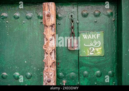 An Arab-culture inspired green exterior door of a Zanzibari home with wooden carvings, door nails and a sign indicating that this is Number 2 Stand St Stock Photo