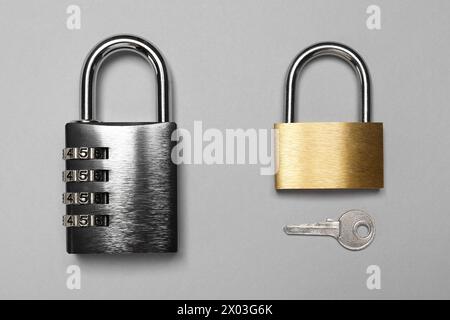 Different padlocks and key on grey background, top view Stock Photo