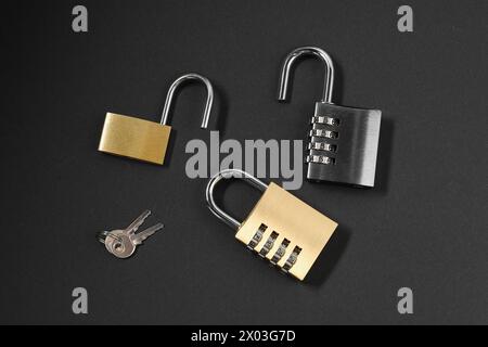 Different padlocks on black background, flat lay Stock Photo