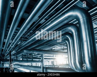 Network of gleaming steel pipes runs with precision, illustrating vital veins of industrial facility. Abstract pipe industry background Stock Photo