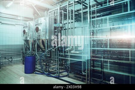 Shiny metal tanks and piping in contemporary beer brewing facility. Stock Photo