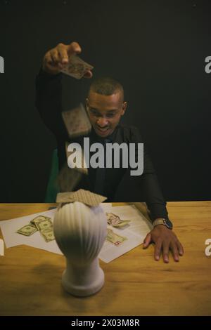 African American man playing cards at casino with mannequin head. Concept Stock Photo