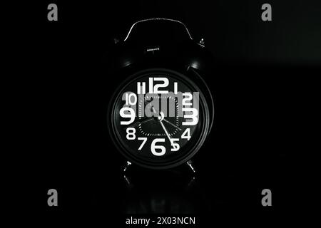 Close up of Black retro alarm clock on dark background Stock Photo