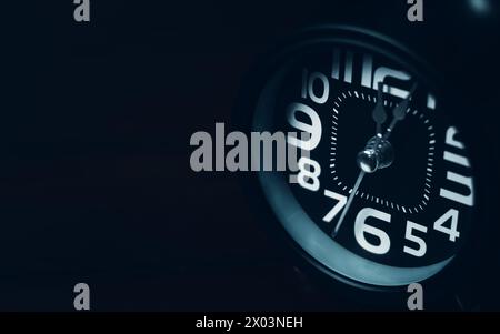 Close up of Black retro alarm clock on dark background Stock Photo