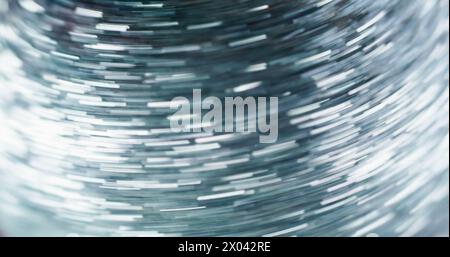 Glitter pattern. Fast motion effect. Dynamic light. Defocused silver color shiny sparkle sequin texture shimmering long exposure glow trails abstract art background. Stock Photo
