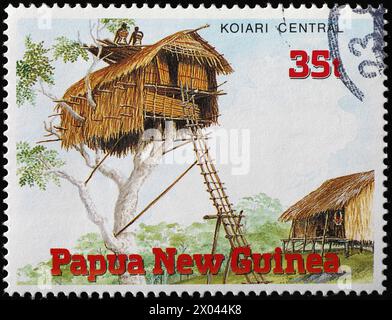 Hut built on a tree on stamp from Papua New Guinea Stock Photo