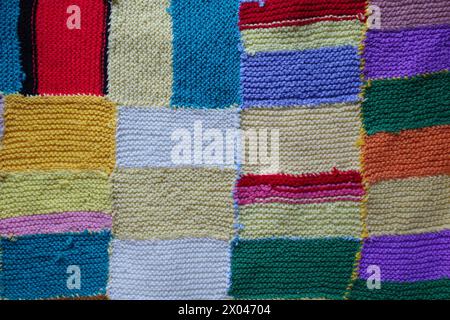 Colorfull knitted patchwork blanket stitched together. Stock Photo