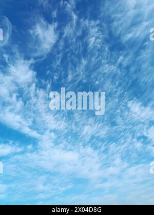 Cluster of high-altitude cirrus cumulus clouds against the background of the blue sky in April Stock Photo