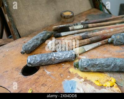 Used Artist paint brush, tube and palette of colorful oil paint on wooden background, for drawing and painting Stock Photo