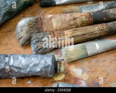 Used Artist paint brush, tube and palette of colorful oil paint on wooden background, for drawing and painting Stock Photo