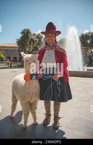 Cusco, Peru - March 2024. Native Peruvian women in Cusco dressed up in traditional colorful clothing with a llama, Cusco Peru. Stock Photo