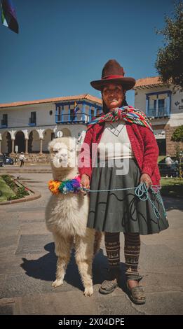 Cusco, Peru - March 2024. Peruvian woman wearing national clothing posing with llama near Cusco Peru. Stock Photo