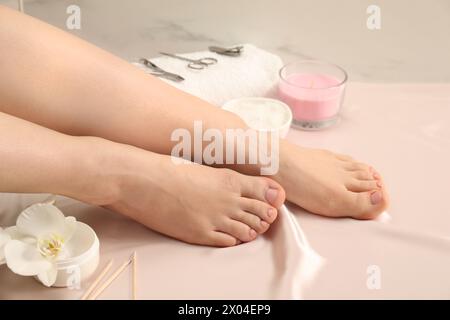 Woman with neat toenails after pedicure procedure on silk fabric, closeup Stock Photo