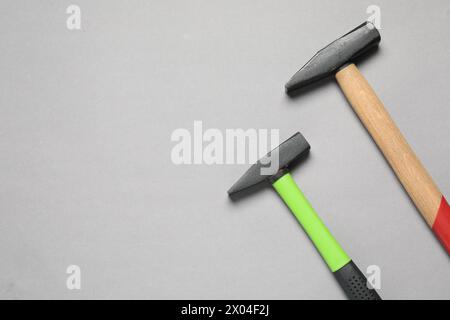 Two hammers on grey background, top view. Space for text Stock Photo