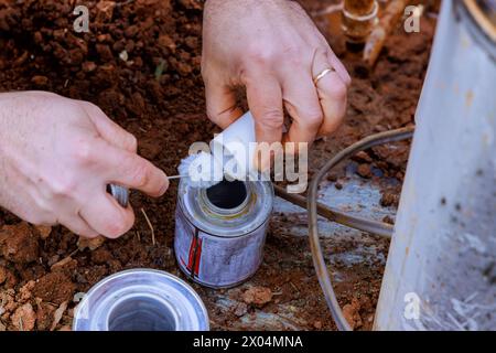 Plumbers use clear primer for PVC pipes before gluing them before completing repair work Stock Photo