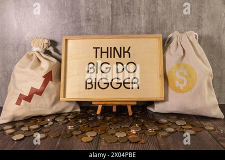 Business concept. Notebook with text Think Big Do Bigger sheet of white paper for notes, calculator, glasses, pencil, pen, in the white background Stock Photo
