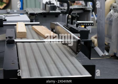 Wood cutting table circular saw machine. Sliding table saw in woodworking workshop. Selective focus. Stock Photo