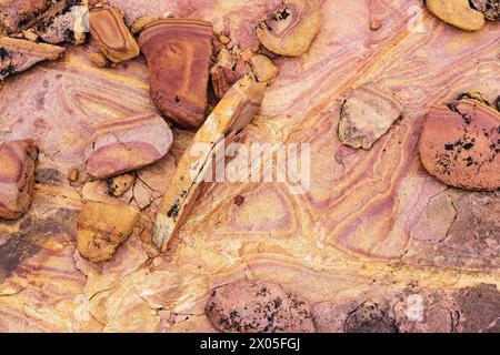 brightly colored sandstone rocks in the rain with banding and cracks Stock Photo