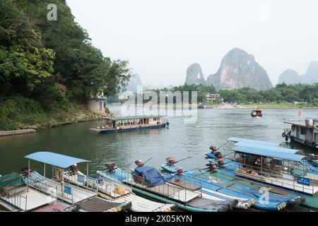 Yangshuo County, Guilin, Guangxi, China -  August 05, 2023:  A row of simple steel pipe structure 'bamboo rafts' used by residents docked at the pier. Stock Photo