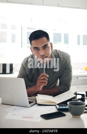 Thinking, man and laptop in kitchen portrait for planning, finances or investment budget for home maintenance. Person, contemplating and making notes Stock Photo