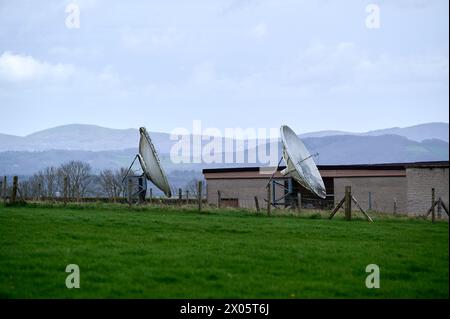 Two old satellite dishes in green field in England Stock Photo
