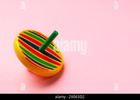 One colorful spinning top on pink background, space for text Stock Photo