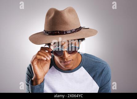 Black man, hat or glasses in vacation, fashion or portrait of confidence on grey studio background. African male person, fedora or eyewear in funky Stock Photo