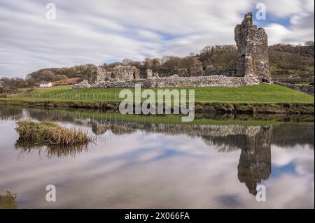 Ogmore Castle, A ruined Norman castle near Bridgend, south Wales. The castle is reflected on the smooth water of the river Ogmore. Stock Photo