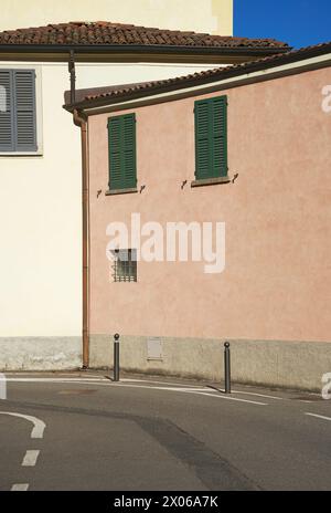 pastel-colored residential buildings with closed wooden window shutters, Italy Stock Photo