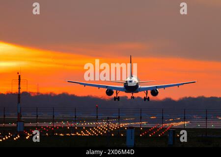 airplane approaching over illuminated runway in the sunset, Germany, Bavaria, Muenchen Stock Photo
