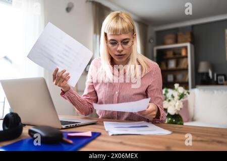 Young sick freelance business woman working at home, work on laptop computer. Online remote working, female wireless connection with company, doing di Stock Photo