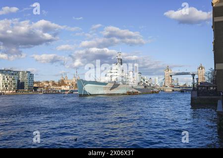 HMS Belfast, Town Class light cruiser from Second World War. Now museum ship moored on south bank River Thames  with Tower Bridge in the background Stock Photo