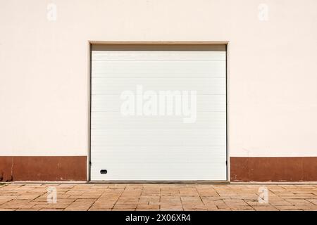 White roller door. Metallic Roller Door Shutter in Front of cream wall. Stock Photo