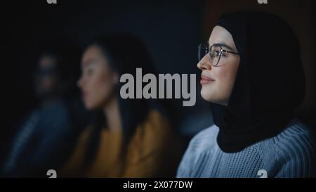 Beautiful Close Up Portrait of a Multiethnic Muslim Female Wearing Hijab and Glasses, Charmingly Smiling and Posing on Camera. Happy Diverse Young Woman in Casual Clothes Indoors. Stock Photo