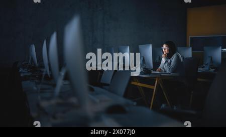 Young Muslim Female Student Sitting Alone in College Informatics Room, Working Late Evenings on Computer Science Project. Scholar Study IT on Computer in University, Writing Homework in Class. Stock Photo