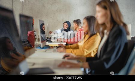 Smart Young Students Studying in University with Diverse Multiethnic Classmates. Scholars Collaborate in College Room with Computers. Applying Knowledge to Acquire Academic Skills in Class. Stock Photo