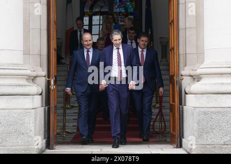 New Taoiseach Simon Harris (centre) with Tanaiste Micheal Martin (left) and Green Party Leader Eamon Ryan (right) ahead of a photocall with his newly appointed Ministers of State on the steps of the Government Buildings in Dublin. Picture date: Wednesday April 10, 2024. Stock Photo