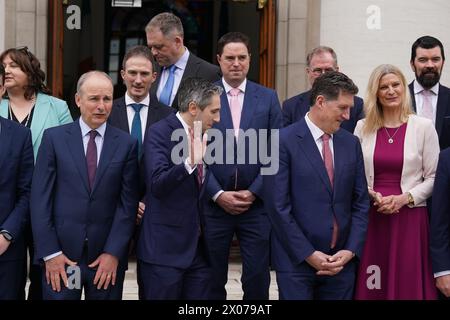 (Front row) New Taoiseach Simon Harris (centre) with Tanaiste Micheal Martin (left) and Green Party Leader Eamon Ryan (right) ahead of a photocall with his newly appointed Ministers of State on the steps of the Government Buildings in Dublin. Picture date: Wednesday April 10, 2024. Stock Photo
