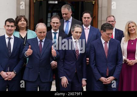 (Front row) New Taoiseach Simon Harris (centre) with Tanaiste Micheal Martin (second from left) and Green Party Leader Eamon Ryan (right) ahead of a photocall with his newly appointed Ministers of State on the steps of the Government Buildings in Dublin. Picture date: Wednesday April 10, 2024. Stock Photo