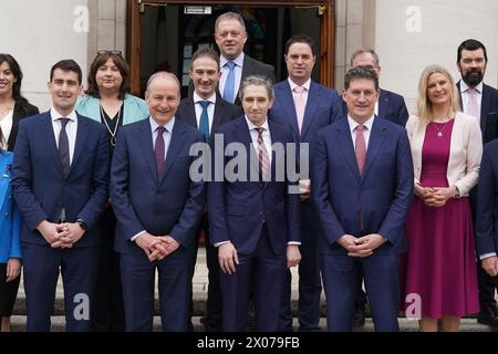 (Front row) New Taoiseach Simon Harris (centre) with Tanaiste Micheal Martin (second from left) and Green Party Leader Eamon Ryan (right) ahead of a photocall with his newly appointed Ministers of State on the steps of the Government Buildings in Dublin. Picture date: Wednesday April 10, 2024. Stock Photo