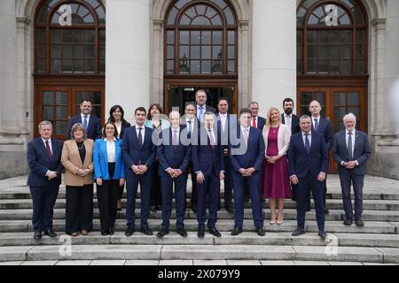 (Front row) New Taoiseach Simon Harris (centre) with Tanaiste Micheal Martin (fifth from left) and Green Party Leader Eamon Ryan (fourth from right) ahead of a photocall with his newly appointed Ministers of State on the steps of the Government Buildings in Dublin. Picture date: Wednesday April 10, 2024. Stock Photo