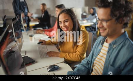 Diverse Multiethnic Group of Female and Male Students Sitting in College Room, Collaborating on School Projects on a Computer. Young Scholars Study, Talk, Apply Academic Skills and Knowledge in Class. Stock Photo