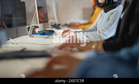 Close Up on Hands of Diverce Group of Students Sitting in College Room, Learning Computer Science. Young Scholars Study Information Technology on Computers in University, Writing Code in Class. Stock Photo
