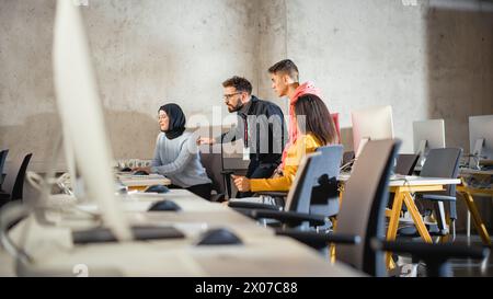 Diverse Multiethnic Group of Female and Male Students Sitting Together in Infographics Room, Collaborating on a College Project. Young Scholars Talking, Study Software Development or Computer Science. Stock Photo