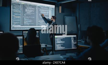 Teacher Giving Computer Science Lecture to Diverse Multiethnic Group of Female and Male Students in Dark College Room. Projecting Slideshow with Programming Code. Explaining Information Technology. Stock Photo