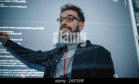 Teacher Giving Computer Science Lecture to Diverse Multiethnic Group of Female and Male Students in Dark College Room. Projecting Slideshow with Programming Code. Explaining Information Technology. Stock Photo
