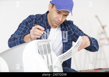 man assembling air conditioning unit Stock Photo