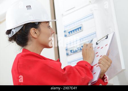 a lady inspecting fuse board Stock Photo
