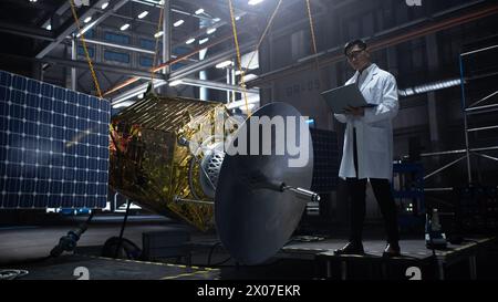 Industrial Engineer Working on Artificial Satellite Construction. Aerospace Agency: Scientist Using Laptop Computer to Develop Spacecraft for Space Exploration and Data Communication. Stock Photo