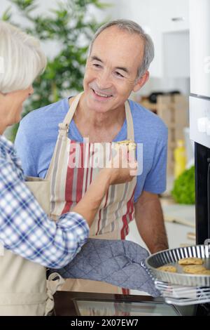 smiling elderly spouses enjoying tea with sweets Stock Photo